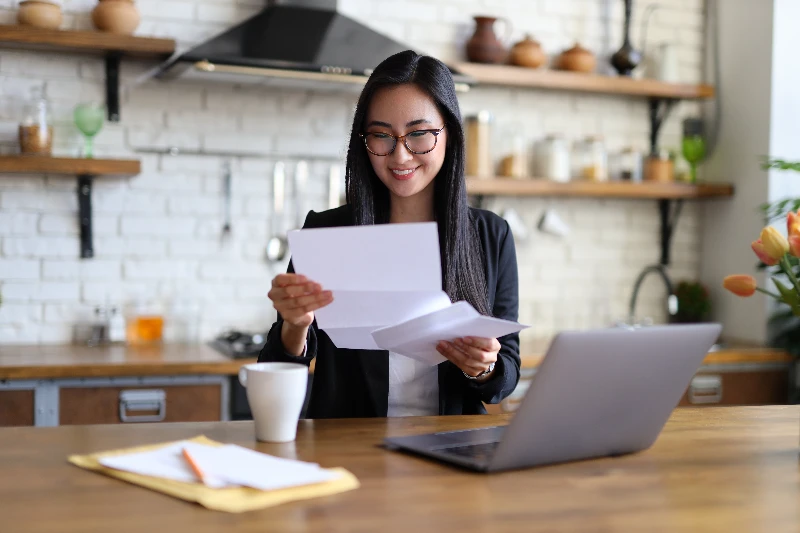 Businesswoman happily reads a finance letter at her desk